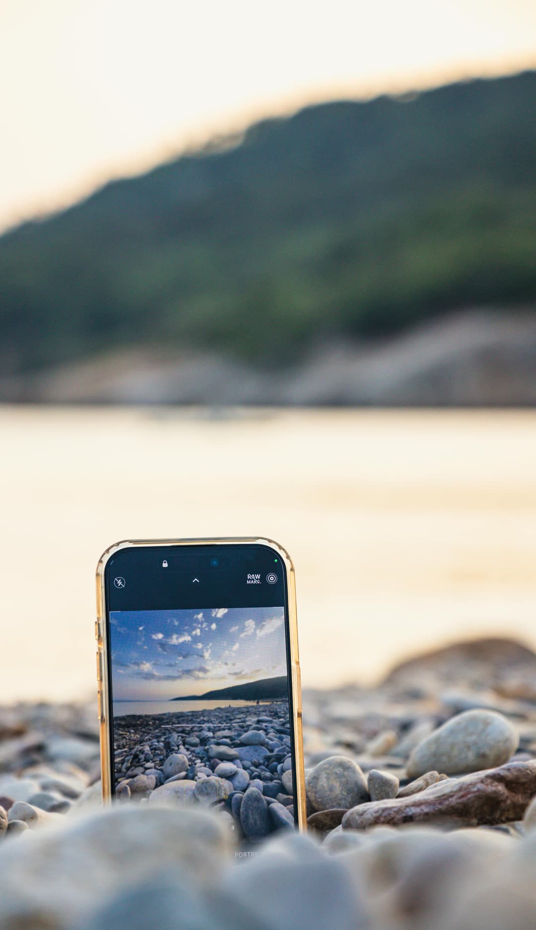 Smart phone placed on rocks by water
